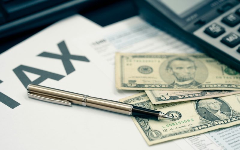 Tax season concept. Tax planning and consulting service business. Pen, calculator, dollar banknote